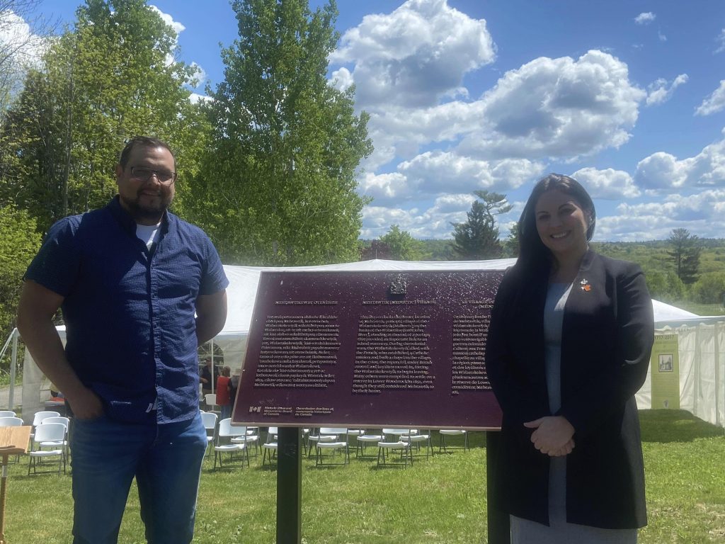 - Shane Perley Dutcher, councillor Tobique First Nation, and ITANB Board member, and MLA Jenica Atwin standing infront of plaque marking the Mehtawtik (Meductic) Village National Historic Site.